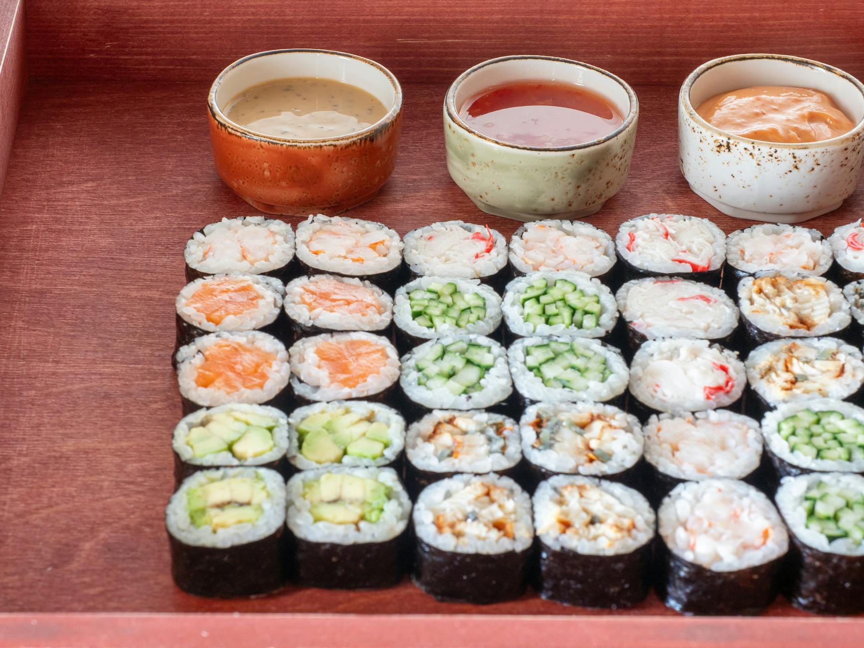 A tray of sushi rolls and sauces