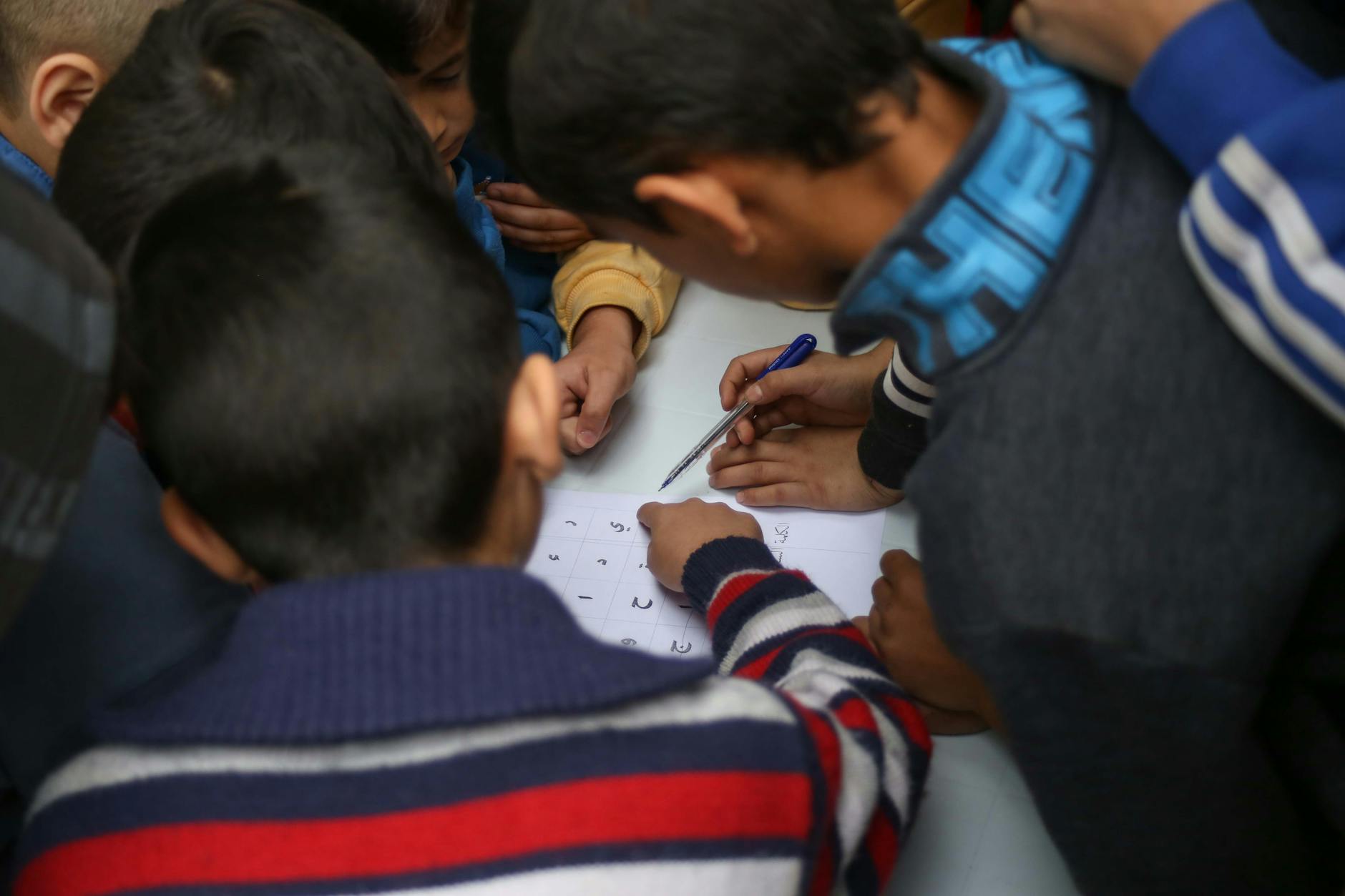 Children are writing on a white board