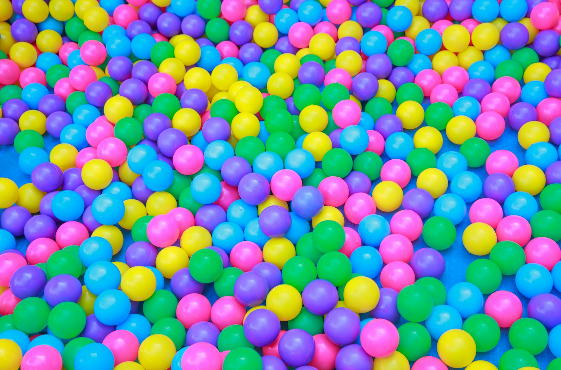 From above of colorful plastic balls in dry pool for kids to jump and play in playroom