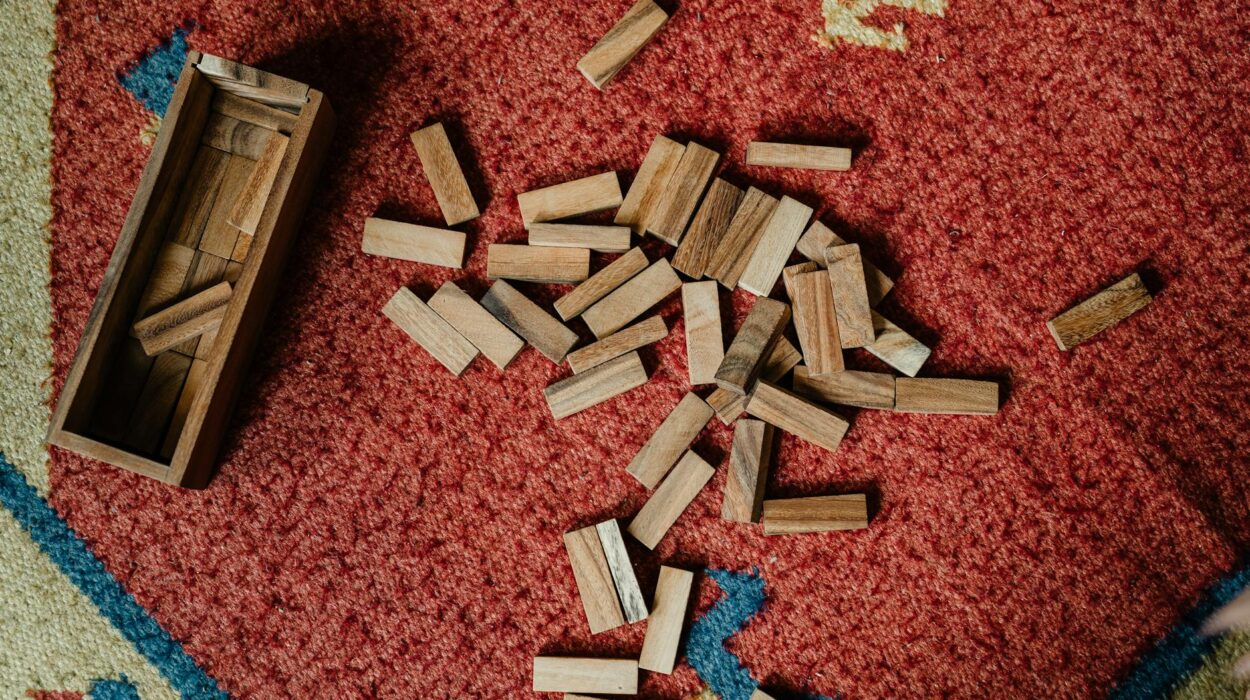 Top view of wooden box and pile of blocks for playing in jenga tower game arranged on floor carpet