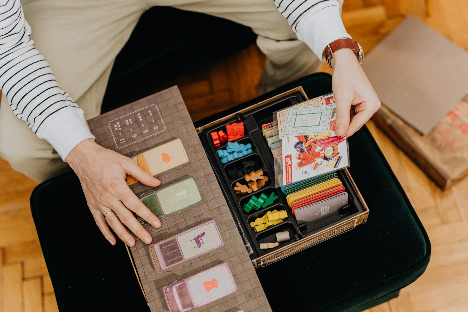 High Angle View of a Man Opening a Vintage Board Game and Finding Ration Cards